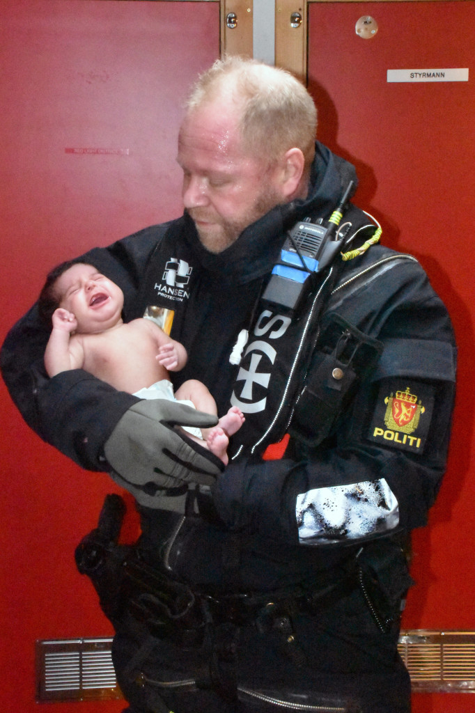 Bildet viser en baby og en redningsmann
